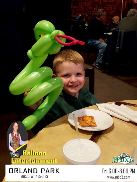 boy holding a balloon snake